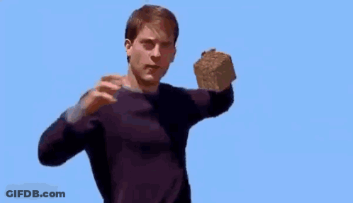 A Man In A Purple Sweater Is Holding A Large Rock In His Hand . GIF