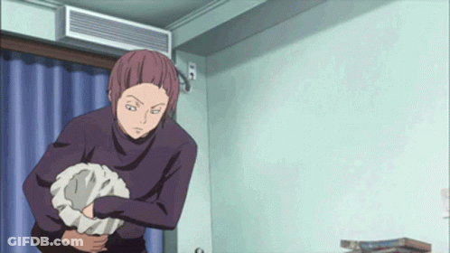 A Man In A Purple Sweater Is Holding A Pillow In His Hand GIF