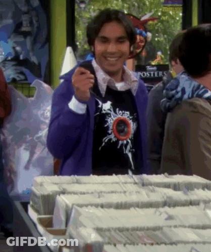 Man In Purple Sweater Standing By Posters GIF