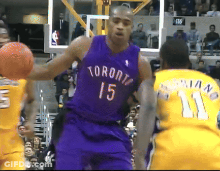A Man In A Purple Toronto Jersey Holds A Basketball GIF