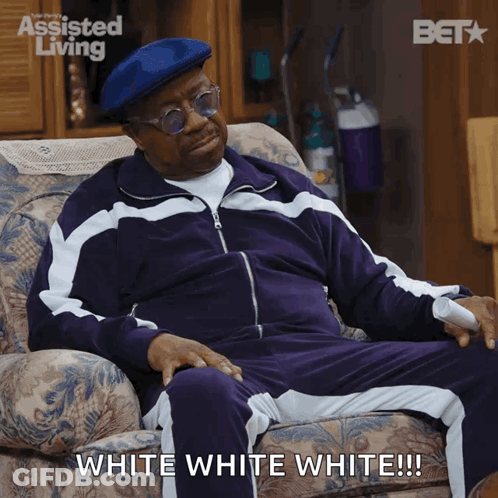 Man In Purple Tracksuit Sitting With White White White Caption GIF