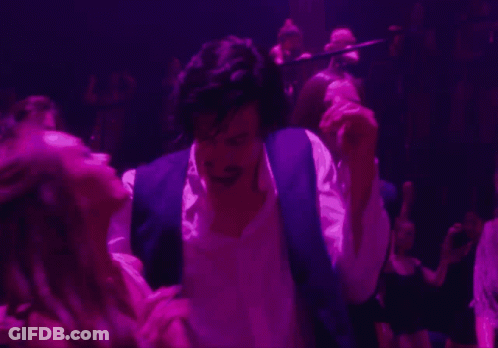 A Man In A Purple Vest Is Dancing With A Woman In A Pink Dress GIF
