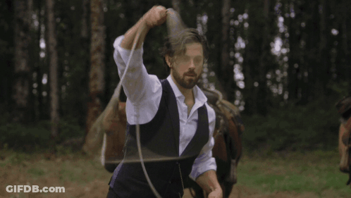 A Man In A Purple Vest Is Lassoing A Small Black Calf GIF