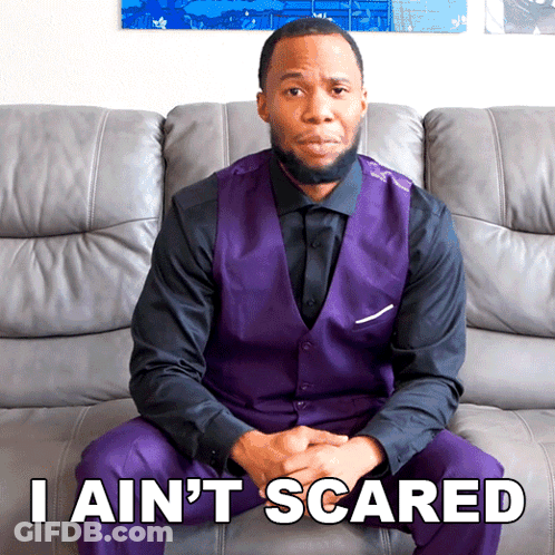 A Man In A Purple Vest Is Sitting On A Couch With The Words I Ain 'T Scared GIF