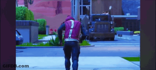 A Man In A Purple Vest Is Walking Down The Street In Front Of A Truck . GIF