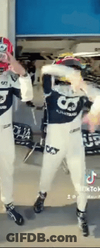 A Man In A Racing Suit Is Dancing With Another Man In A Racing Suit . GIF