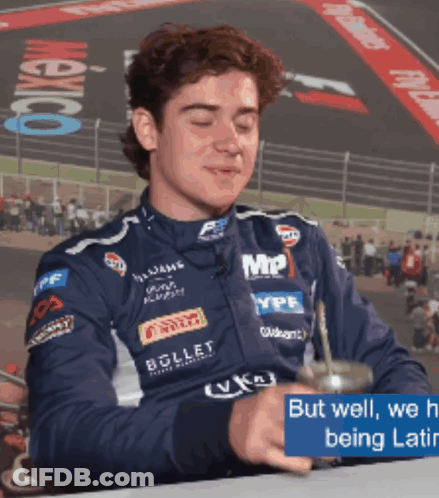 A Man In A Racing Suit Is Drinking From A Cup With The Words But Well We 'Re Being Latin GIF