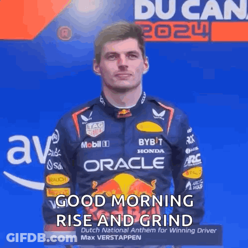 A Man In A Racing Suit Is Standing In Front Of A Blue Wall And Says Good Morning Rise And Grind . GIF