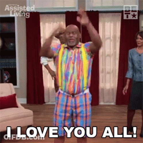 A Man In A Rainbow Shirt And Shorts Is Dancing In A Living Room While A Woman Stands Behind Him . GIF
