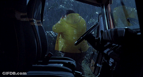 A Man In A Raincoat Is Driving A Car GIF