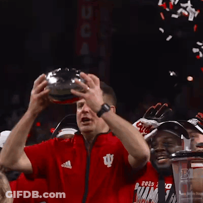 A Man In A Red Adidas Shirt Holds A Trophy In His Hands GIF