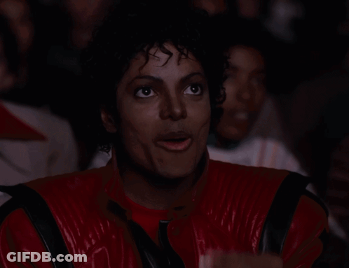 A Man In A Red And Black Jacket Is Eating Popcorn GIF