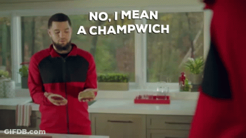 A Man In A Red And Black Jacket Says No I Mean A Champwich While Standing In A Kitchen GIF