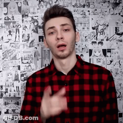 A Man In A Red And Black Plaid Shirt Is Standing In Front Of A Wall Of Comic Strips . GIF