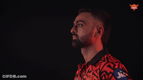 A Man In A Red And Black Shirt With Jio Written On His Sleeve GIF
