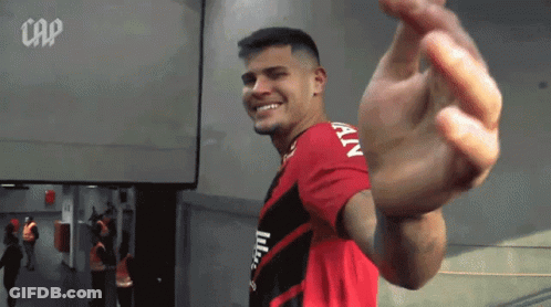 A Man In A Red And Black Shirt With The Word Cap On The Bottom GIF