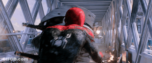 A Man In A Red And Black Spiderman Suit Is Flying Through The Air GIF