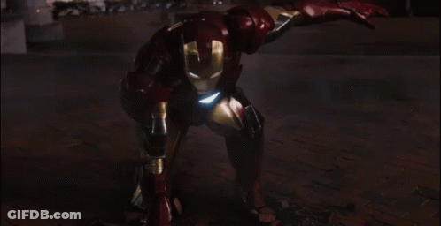 A Man In A Red And Gold Iron Man Suit Is Standing In Front Of A Building GIF