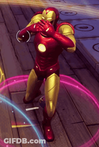 A Man In A Red And Gold Superhero Suit Is Standing On A Wooden Floor GIF