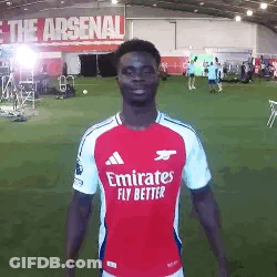 A Man In A Red And White Emirates Fly Better Soccer Jersey Is Standing On A Field . GIF