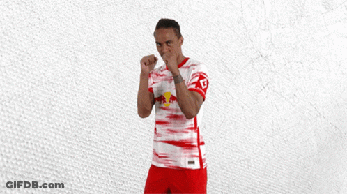 A Man In A Red And White Jersey With A Red Bull On The Front GIF