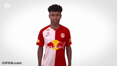 A Man In A Red And White Redbull Jersey GIF