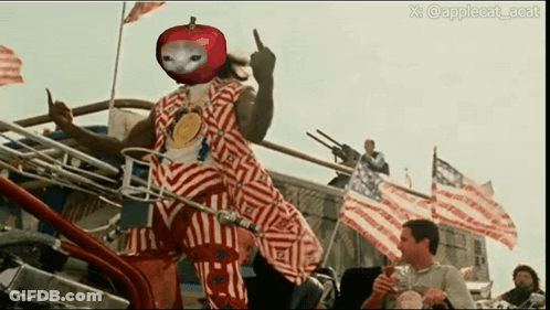 A Man In A Red And White Striped Outfit With An Apple On His Head GIF