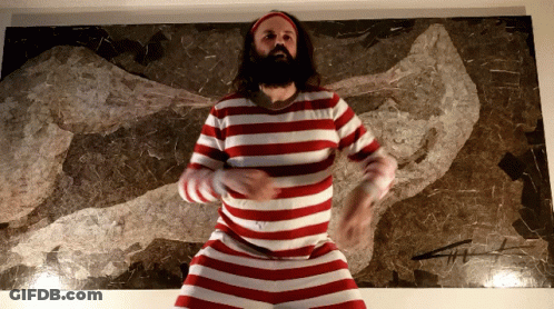 A Man In A Red And White Striped Shirt Is Dancing In Front Of A Painting GIF