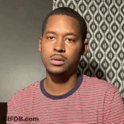 A Man In A Red And White Striped Shirt Is Making A Face . GIF