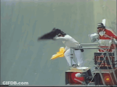 A Man In A Red And White Uniform Is Standing On A Ladder GIF