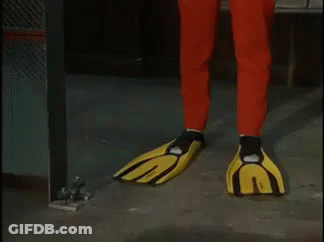 A Man In A Red And Yellow Superhero Costume Is Standing In A Room . GIF