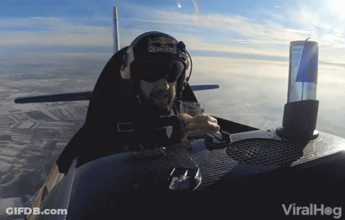 A Man In A Red Bull Helmet Sits In A Small Plane GIF