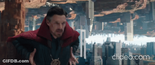 A Man In A Red Cape Is Standing In Front Of A City With The Words Clideo.com Below Him . GIF