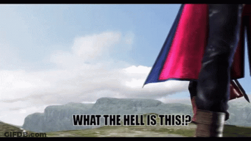 A Man In A Red Cape Is Standing In Front Of A Mountain With The Words What The Hell Is This Written Below Him GIF