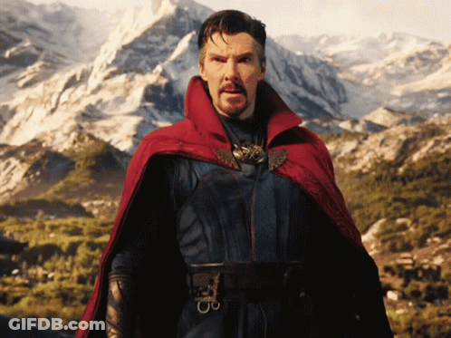 A Man In A Red Cape Stands In Front Of A Snowy Mountain GIF