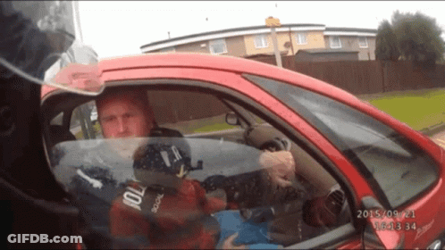 A Man In A Red Car Has A Helmet On That Says Police On It GIF