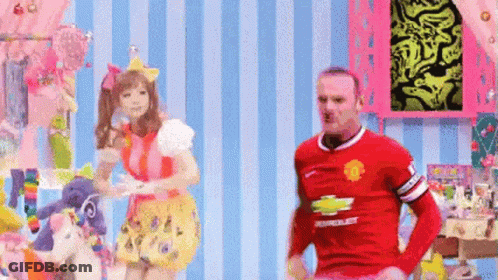 A Man In A Red Chevrolet Jersey Is Standing Next To A Woman In A Pink Dress GIF