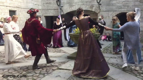 A Man In A Red Coat Is Dancing With A Woman In A Purple Dress GIF