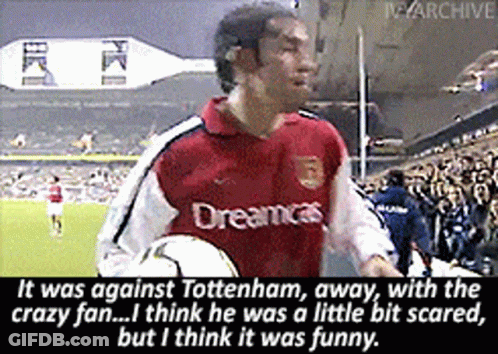 A Man In A Red Dreamcast Jersey Holds A Soccer Ball In Front Of A Crowd GIF