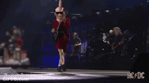A Man In A Red Dress Is Giving A Middle Finger While Playing A Guitar GIF