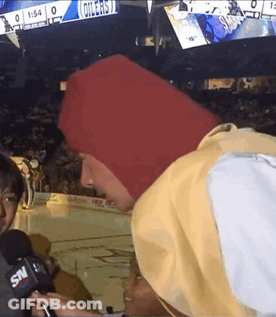 A Man In A Red Hat Is Being Interviewed By A Snv Reporter . GIF