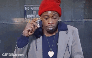 A Man In A Red Hat Is Eating A Sandwich In Front Of A No Parking Sign GIF