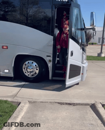 A Man In A Red Hat Is Getting Off A Bus That Says ' To You ' On The Side GIF