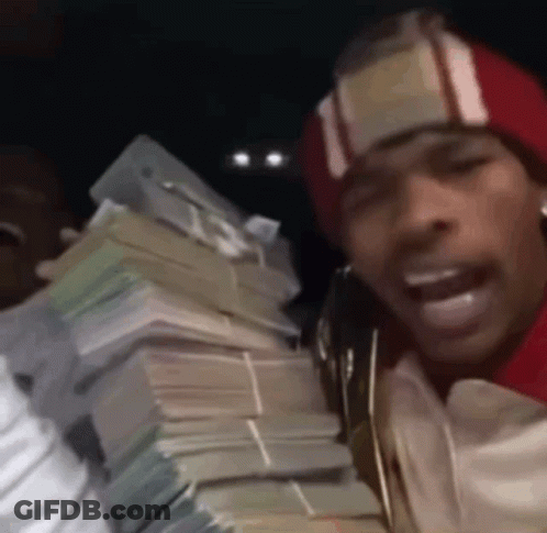 A Man In A Red Hat Is Holding A Large Pile Of Money . GIF