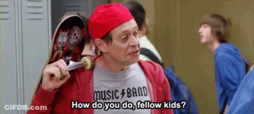 A Man In A Red Hat Is Holding A Skateboard And Talking To A Group Of Kids . GIF