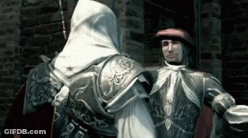 Man In Red Hat Next To Man In White Hood GIF