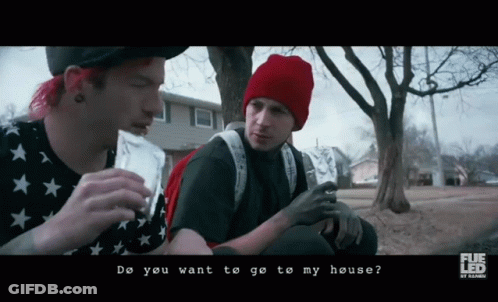 A Man In A Red Hat Is Talking To Another Man In A Black Shirt GIF