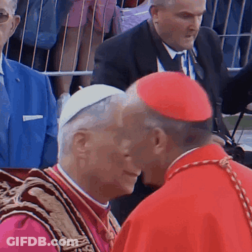 A Man In A Red Hat Talks To Another Man GIF