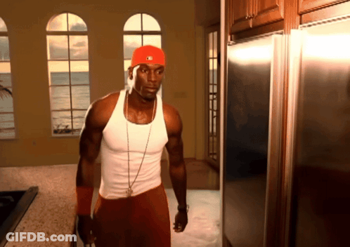 A Man In A Red Hat With The Letter M On It Stands In A Kitchen GIF