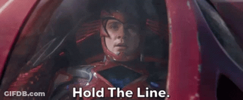 A Man In A Red Helmet Is Sitting In A Car And Says Hold The Line . GIF